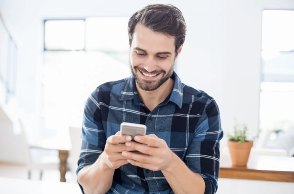 man smiling at cell phone